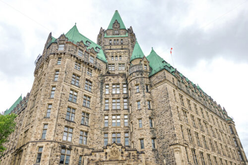 Shot of the Confederation Building in Ottawa with gray and cloudy sky in the background - Starpik