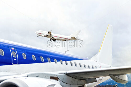 Taking off aircraft at the airport in cold weather, big blue plane wings close up, diagonal lines - Starpik