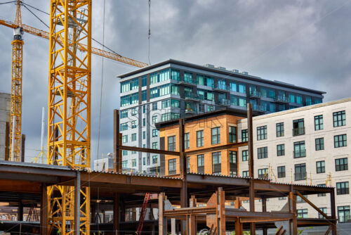 The construction process. Blue and orange building on background. Cloudy sky - Starpik