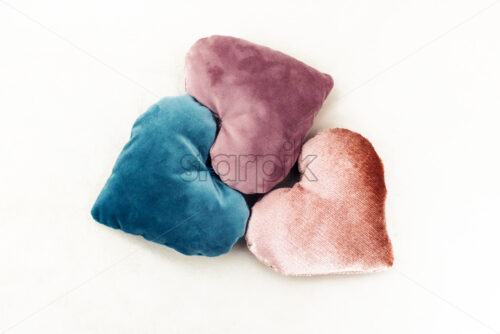 Three heart shaped pillows made up from velvet. Love gifts for couples. Rose, teal and purple colors. White background - Starpik