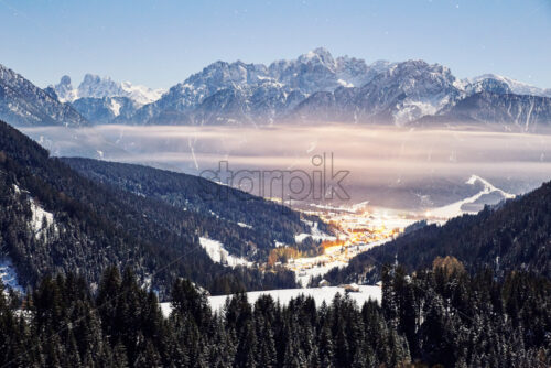 Toblach at sunset with clouds and mountains covered in snow. Italy - Starpik