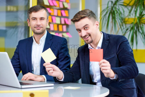 Two mature caucasian male having fun in the office with stickers. Wearing formal clothes. - Starpik