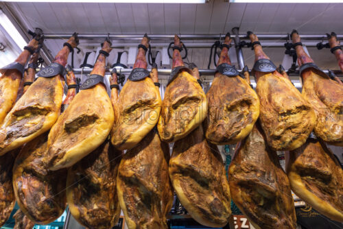 VALENCIA, SPAIN – APRIL 17, 2019: Big pieces of ham for sale at the Valencia’s Central Market - Starpik