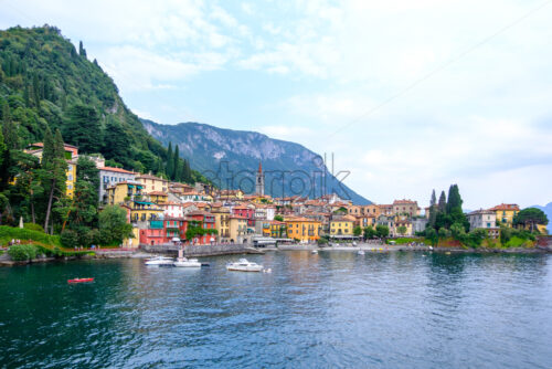 Varenna town at sunset with colorful buildings. Parked yachts. Lake Como, mountains and sky on background. Italy beauties - Starpik