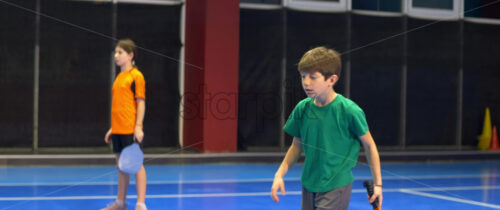 Video A boy and a girl playing pickleball on a blue, inside court - Starpik Stock