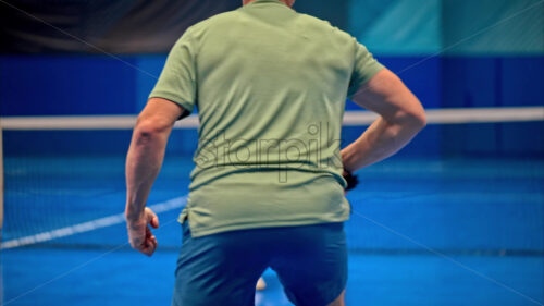 Video A man and a woman training to play pickleball on a blue, inside court - Starpik