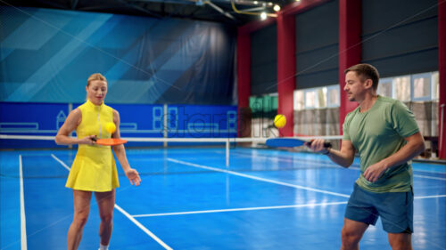 Video A man and a woman training to play pickleball on a blue, inside court - Starpik