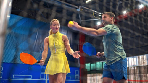 Video A man teaching a woman how to play pickleball in an inside court - Starpik