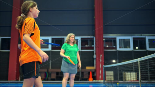 Video A woman and a child playing pickleball on a blue, inside court - Starpik Stock