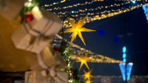 Video Close up of a Christmas garland on a market boutique with blurry lights on the background - Starpik Stock