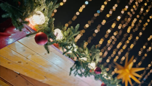 Video Close up of a Christmas garland on a market boutique with blurry lights on the background - Starpik Stock