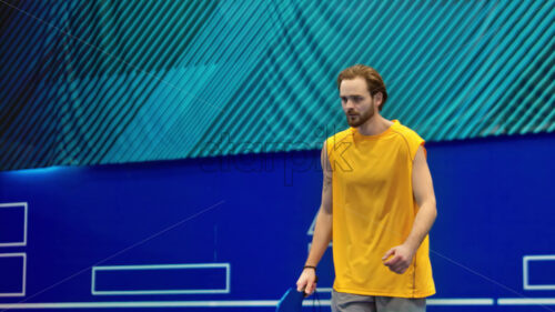 Video Man in yellow shirt playing pickleball on a blue, inside court - Starpik