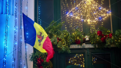 Video The flag of Moldova waving in front of the Organ Hall door with Christmas decorations in Chisinau, Moldova - Starpik Stock