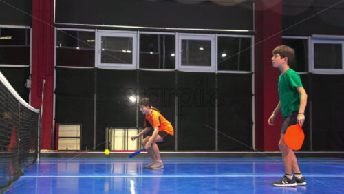 Video Two adults and two children posing after playing pickleball on a blue, inside court - Starpik Stock