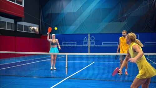 Video Two men and two women playing pickleball on a blue, inside court - Starpik