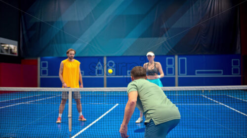 Video Two men and two women playing pickleball on a blue, inside court - Starpik