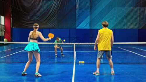 Video Two men and two women playing pickleball on a blue, inside court - Starpik