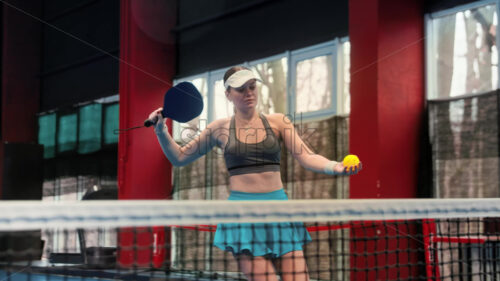 Video Woman playing pickleball on a blue, inside court - Starpik