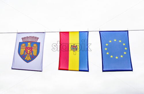 View from bottom to city coat of arms, country and Europe flag at local festival. Negative copy space, place for text. Chisinau, moldova - Starpik