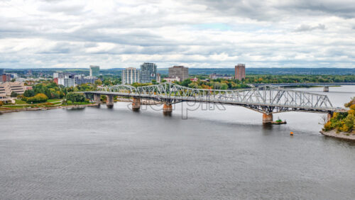 View of Ottawa river, the bridge connecting two provinces, with gray and cloudy sky reflecting in the surface of the water - Starpik