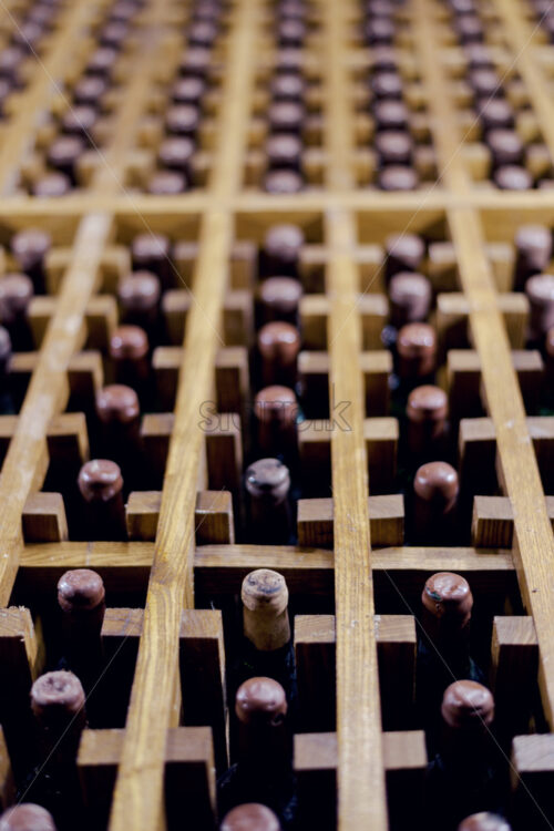 Wine bottles on wooden logs, shallow depth of field - Starpik