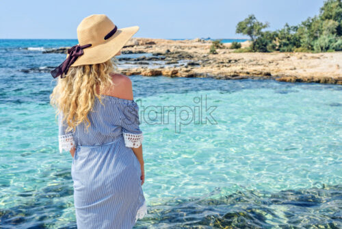 Woman at the beach in Cyprus. Beautiful Summer seaside view. Enjoying sunny day - Starpik