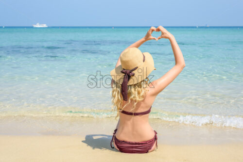 Woman at the beach in Cyprus. Love heart shape with hands. Beautiful Summer seaside view - Starpik