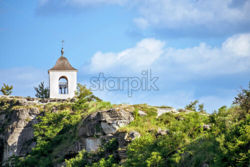 Wonderful landscape with rocks and mountains at orheiul vechi monastery and memorial in moldova, near raut river, blue sky, sunny day, bell tower - Starpik