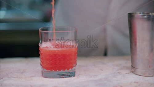 video Barman placing an orange in a cocktail at the bar - Starpik Stock