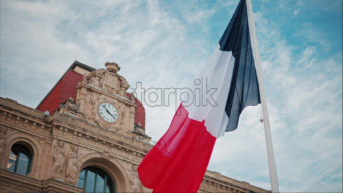 video French flag waving in front of the Mairie de Cannes Town hall in Cannes, France - Starpik Stock