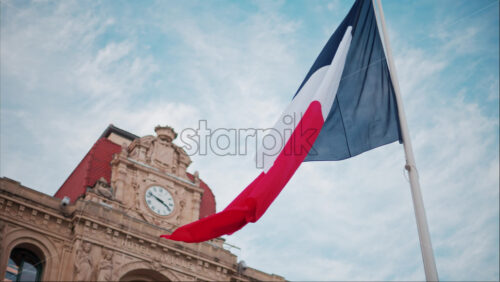 video French flag waving in front of the Mairie de Cannes Town hall in Cannes, France - Starpik Stock