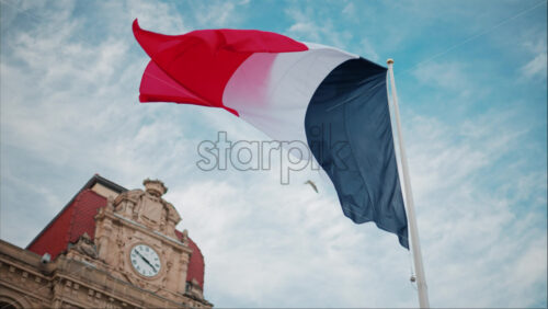 video French flag waving in front of the Mairie de Cannes Town hall in Cannes, France - Starpik Stock