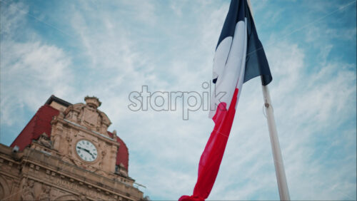 video French flag waving in front of the Mairie de Cannes Town hall in Cannes, France - Starpik Stock