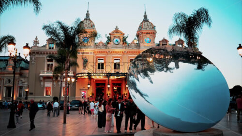 video Monte Carlo, Monaco – October 4, 2024: Sky mirror sculpture in front of The Monte Carlo Casino with people walking around it in the evening - Starpik Stock