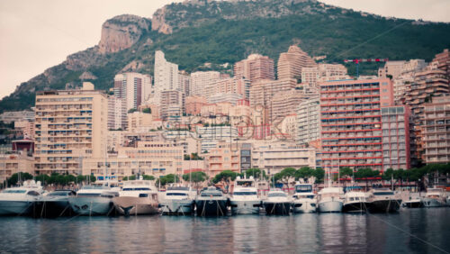 video View of boats docked in the Monaco Marina with the skyline of the city on the background - Starpik Stock