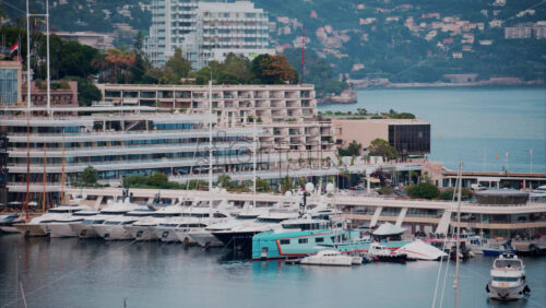 video View of boats docked in the Monaco Marina with the skyline of the city on the background - Starpik Stock