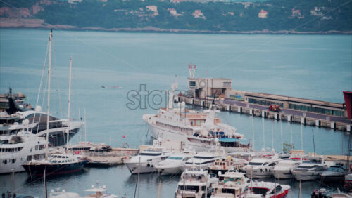 video View of boats docked in the Monaco Marina with the skyline of the city on the background - Starpik Stock