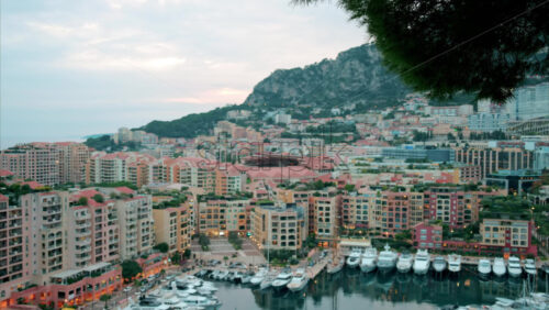 video View of boats docked in the Port de Fontvieille with the skyline of Monaco on the background in the evening - Starpik Stock