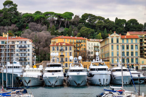 Red and orange buildings in Nice, France, boats and yachts at the Lympia port, green trees - Starpik Stock